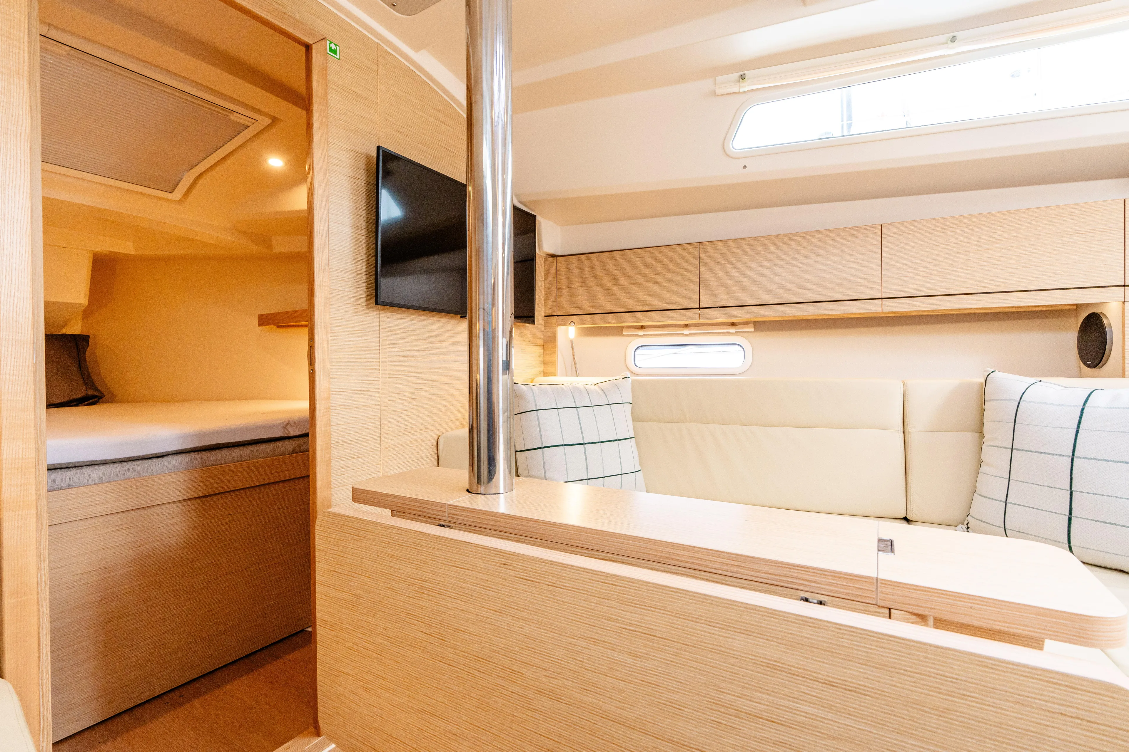 The Siren's Song Yacht Photos Pics 2023 Hanse 348 yacht interior with modern seating, TV, and cozy cabin space.