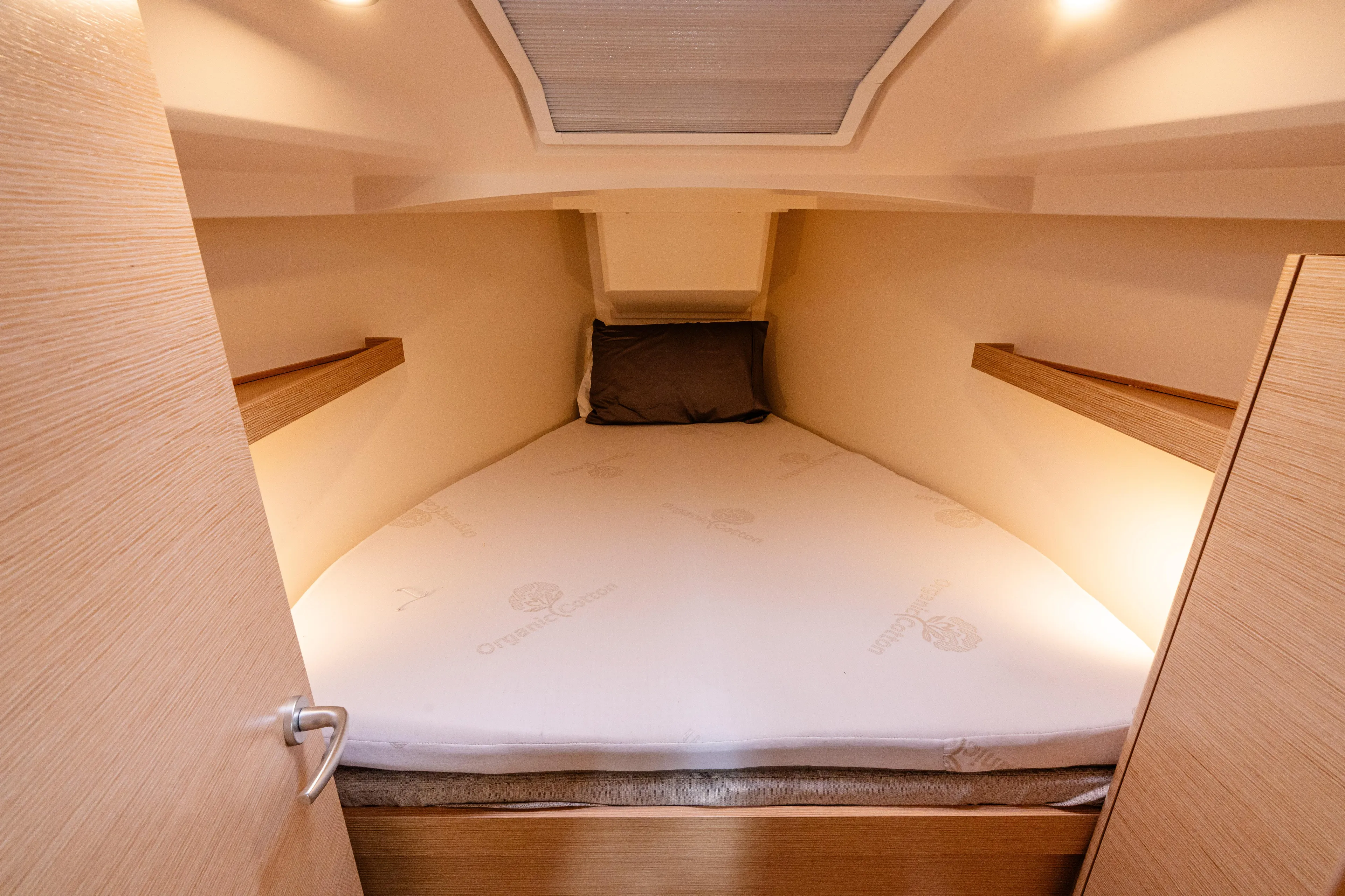The Siren's Song Yacht Photos Pics Cozy cabin interior of 2023 Hanse 348 yacht with comfortable bed and soft lighting.