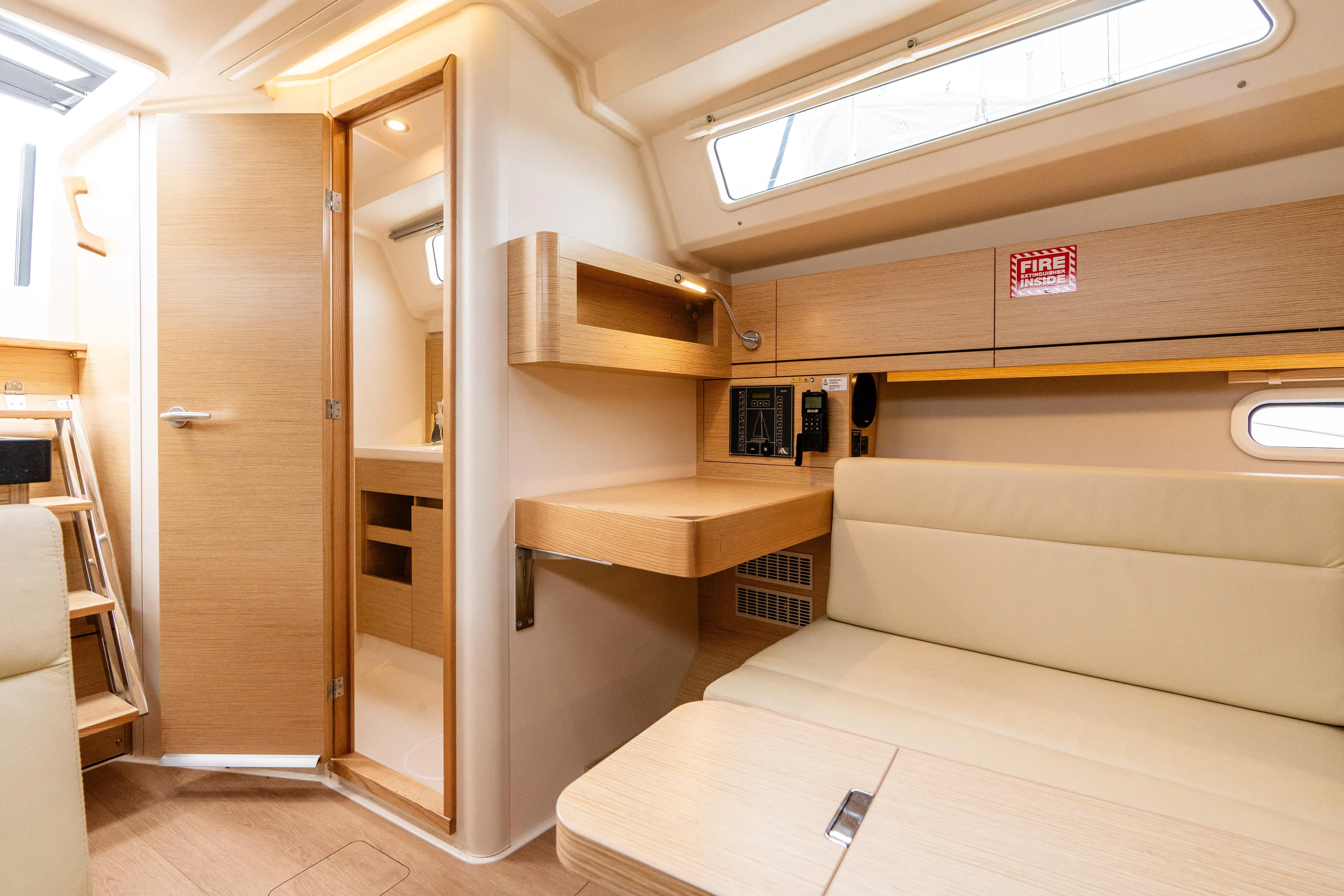 The Siren's Song Yacht Photos Pics 2023 Hanse 348 yacht interior with modern wood finish and seating area.