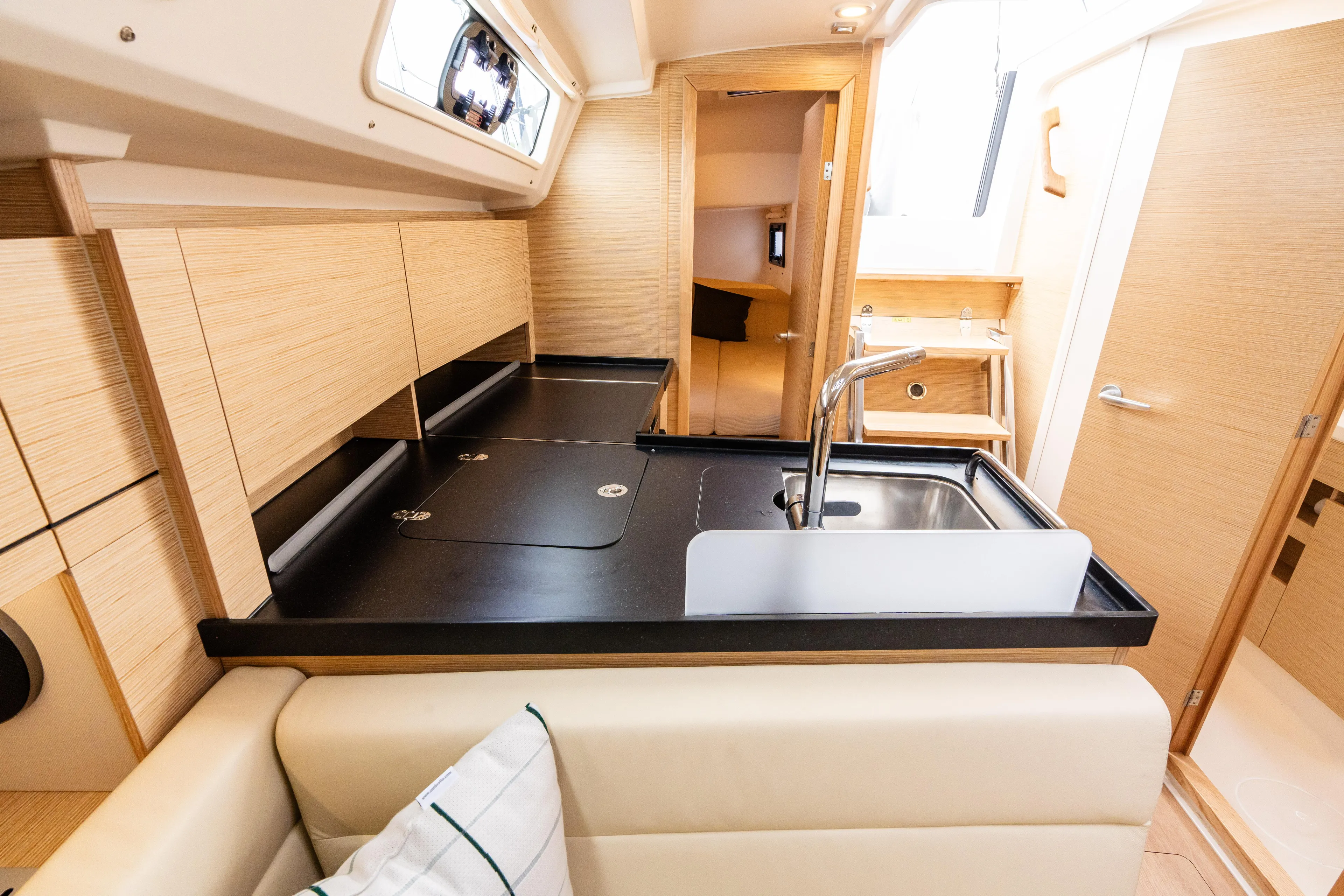 The Siren's Song Yacht Photos Pics Interior of 2023 Hanse 348 yacht, featuring modern kitchen with sleek countertops and wooden cabinetry.