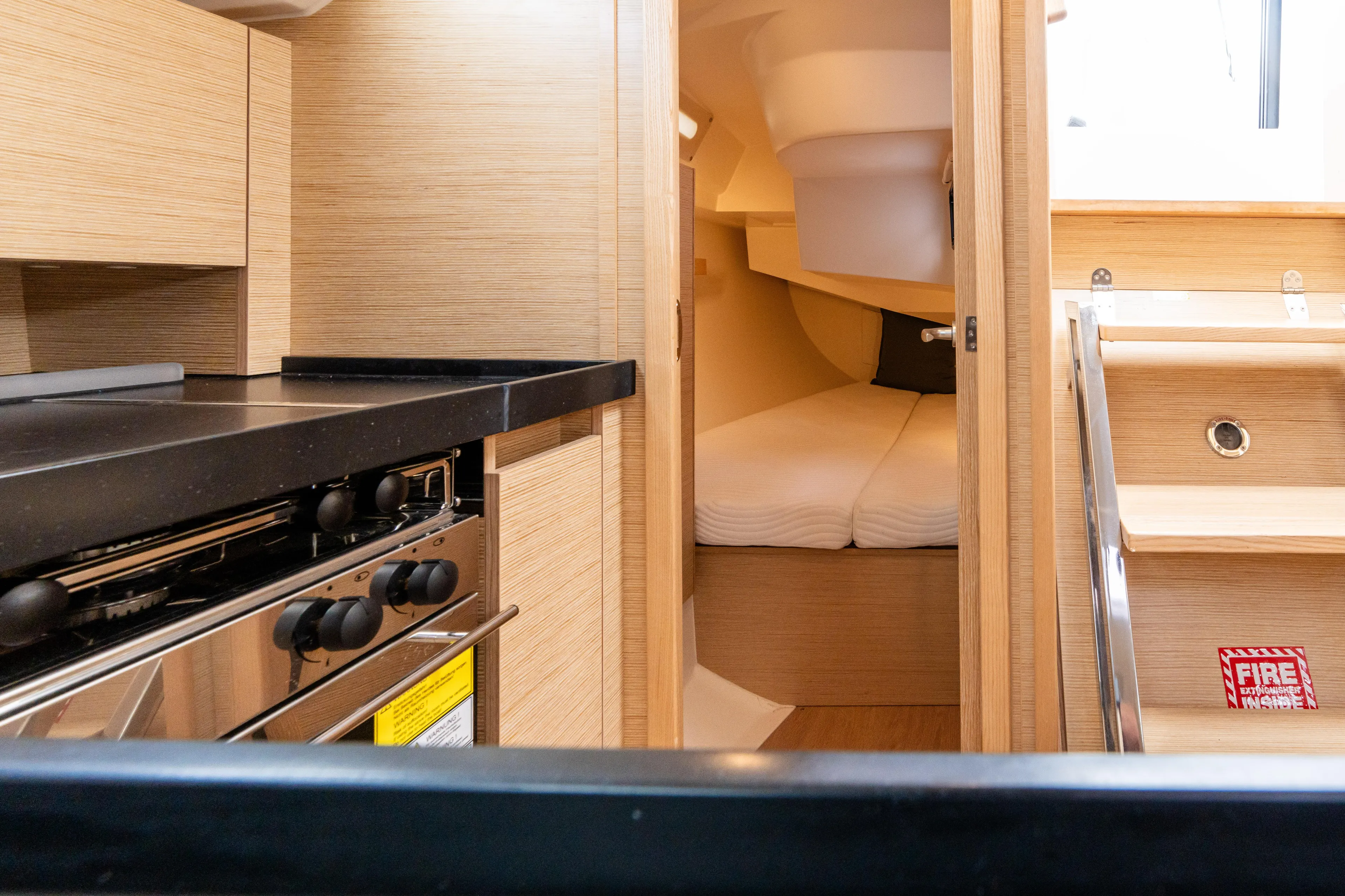 The Siren's Song Yacht Photos Pics Interior of 2023 Hanse 348 yacht featuring a compact kitchen and cozy sleeping area.