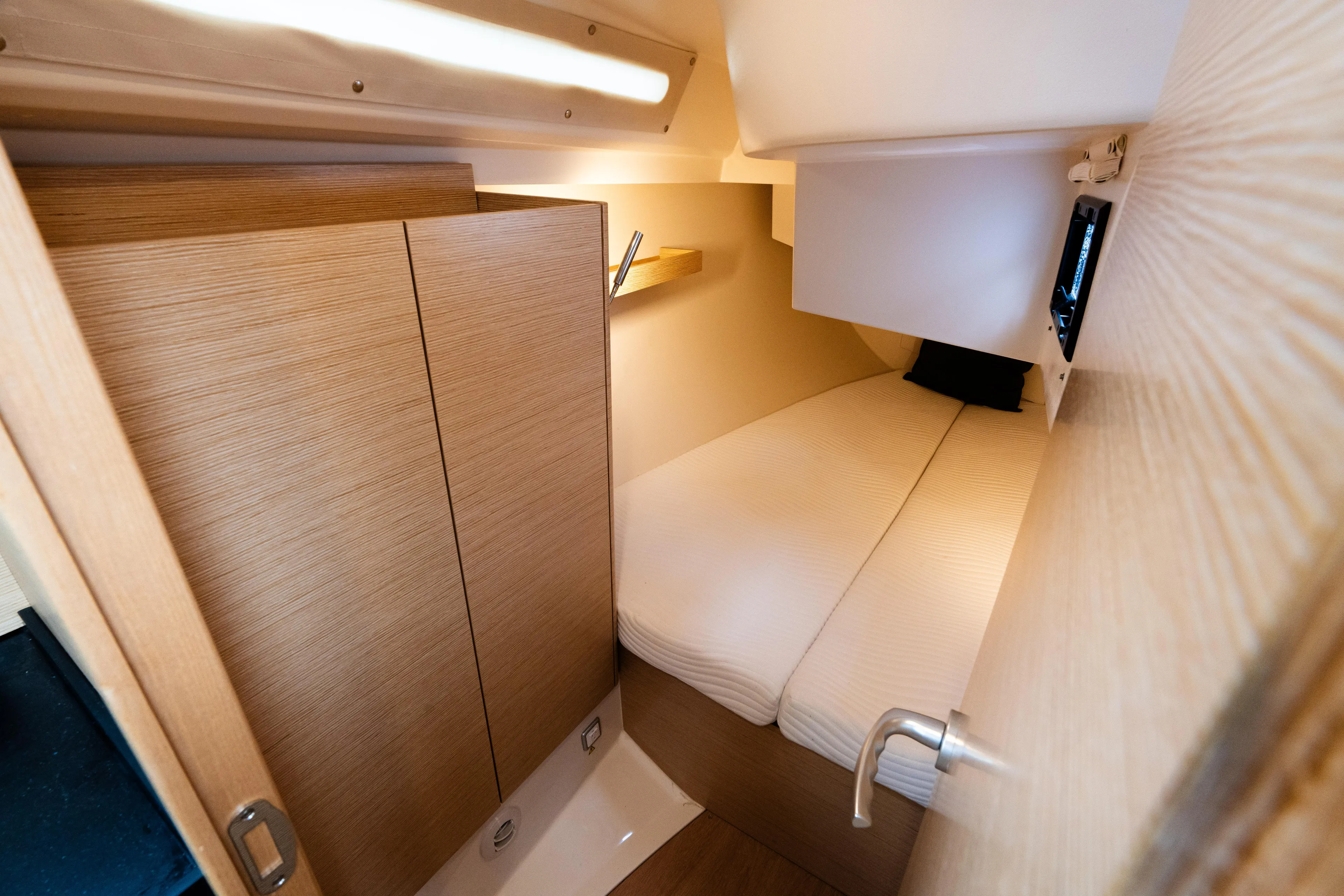The Siren's Song Yacht Photos Pics 2023 Hanse 348 yacht cabin with cozy bed, wooden interior, and modern lighting.