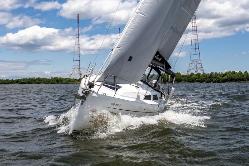 The Siren's Song Yacht Photos Pics 2023 Hanse 348 sailboat navigating choppy waters under a partly cloudy sky.