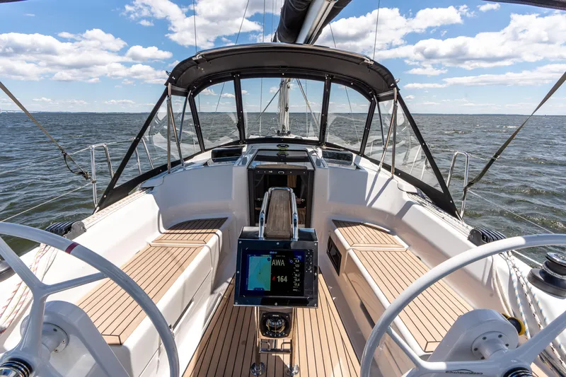 The Siren's Song Yacht Photos Pics 2023 Hanse 348 sailboat cockpit with modern navigation system, sailing on open water.