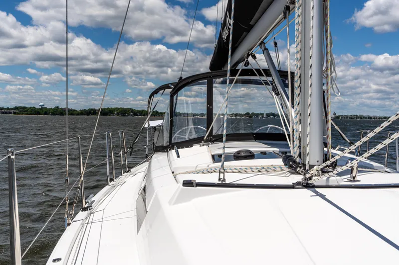 The Siren's Song Yacht Photos Pics 2023 Hanse 348 sailboat on open water under a partly cloudy sky.