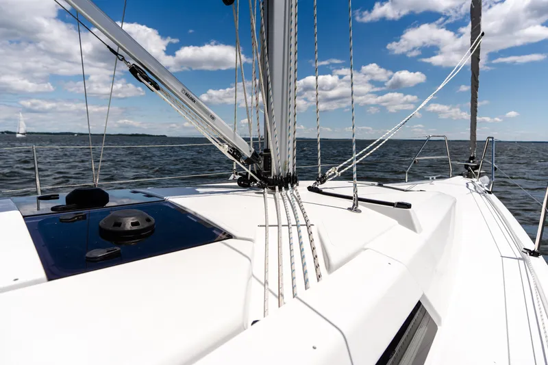 The Siren's Song Yacht Photos Pics 2023 Hanse 348 sailboat deck with ropes, sailing on open water under blue sky.