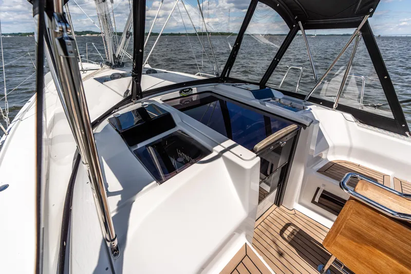 The Siren's Song Yacht Photos Pics 2023 Hanse 348 yacht cockpit with sleek design, wooden flooring, and ocean view.