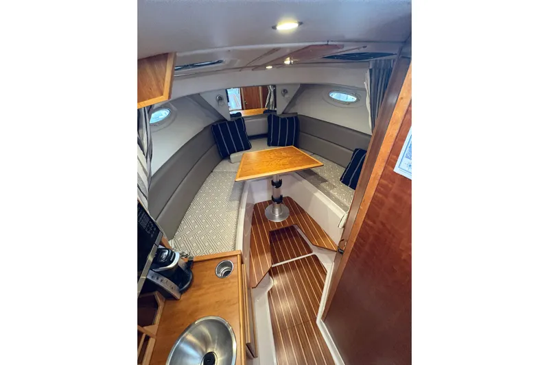 Andiamo Yacht Photos Pics 2020 Cutwater C-28 cabin interior with wood accents and seating area.