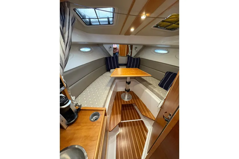 Andiamo Yacht Photos Pics 2020 Cutwater C-28 cabin interior with wood accents and cozy seating area.