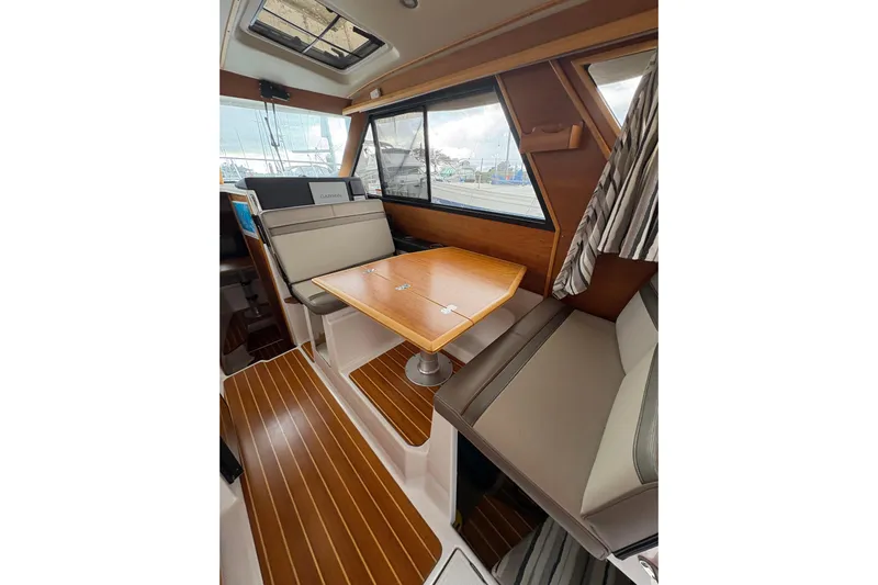 Andiamo Yacht Photos Pics 2020 Cutwater C-28 boat interior with wood flooring, seating, and table.