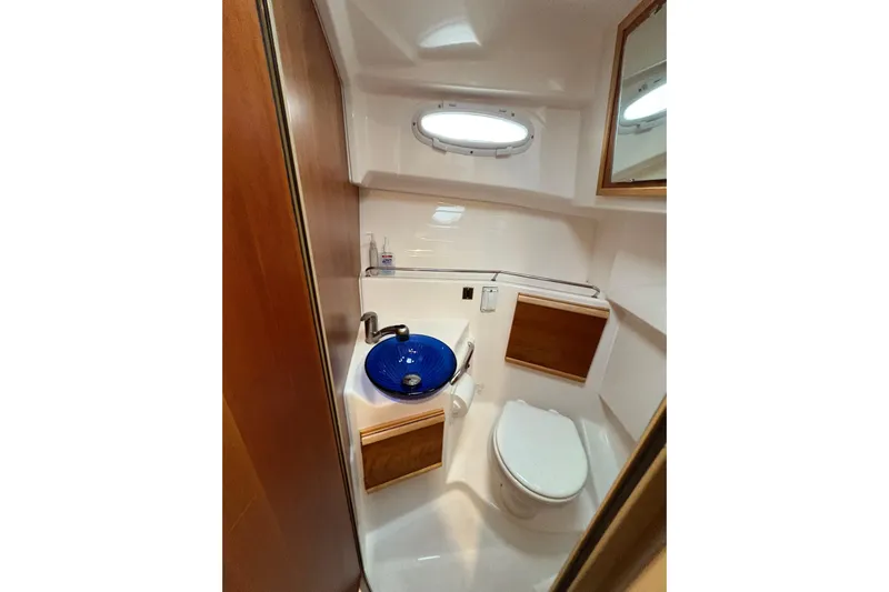 Andiamo Yacht Photos Pics 2020 Cutwater C-28 boat bathroom with blue sink, toilet, and wooden accents.