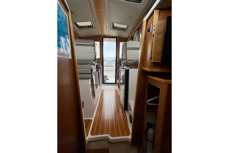 Andiamo Yacht Photos Pics Interior view of 2020 Cutwater C-28 boat, featuring sleek wood flooring and modern seating.