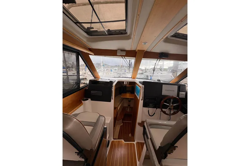 Andiamo Yacht Photos Pics Interior of 2020 Cutwater C-28 boat with modern navigation equipment and wooden accents.