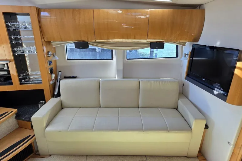  Yacht Photos Pics Luxurious interior of 2009 Four Winns V435 yacht with sofa, TV, and wooden cabinetry.