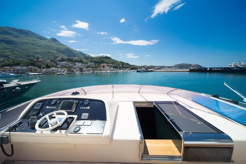 Zia Canaia Yacht Photos Pics Riva Opera 80 yacht helm, 2001 model, overlooking scenic coastal harbor and mountains.