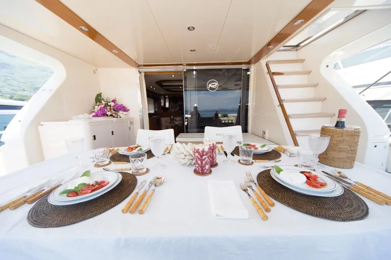 Zia Canaia Yacht Photos Pics Elegant dining setup on 2001 Riva Opera 80 yacht, featuring a beautifully arranged table.