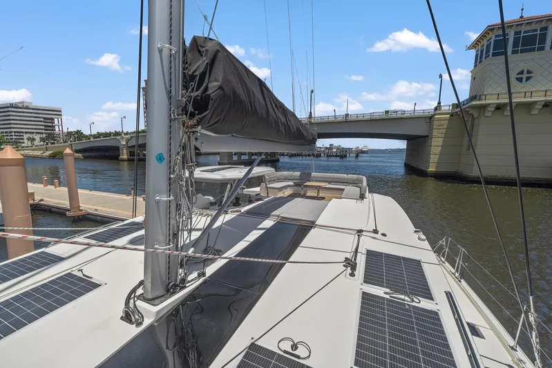One Love Yacht Photos Pics Leopard 50 catamaran docked near a bridge, 2019 model, with solar panels on deck.