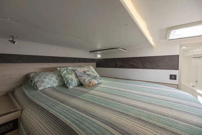 One Love Yacht Photos Pics Cozy bedroom in 2019 Leopard 50 yacht with striped bedding and decorative pillows.