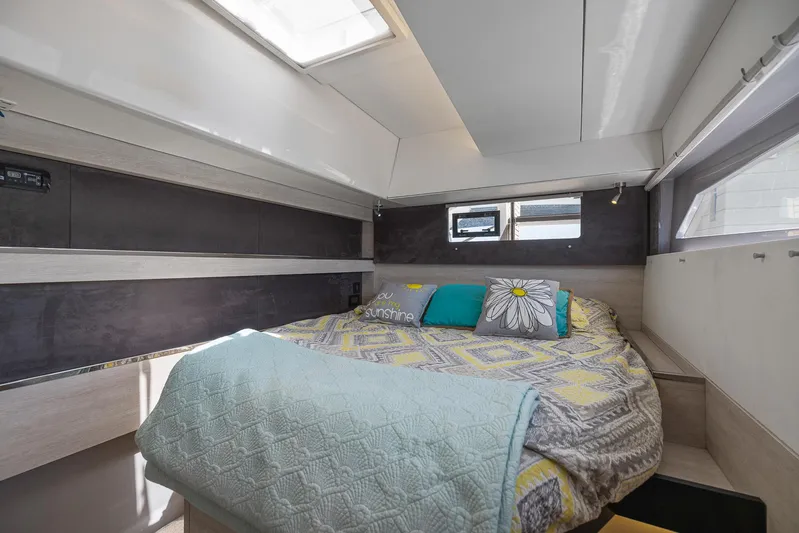 One Love Yacht Photos Pics Cozy bedroom in a 2019 Leopard 50 yacht with modern decor and ample natural light.