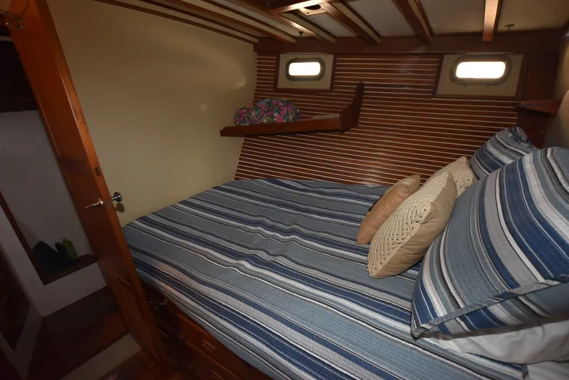 In Do Time Yacht Photos Pics Cozy cabin interior of 1983 Kadey-Krogen Trawler with striped bedding and wooden accents.