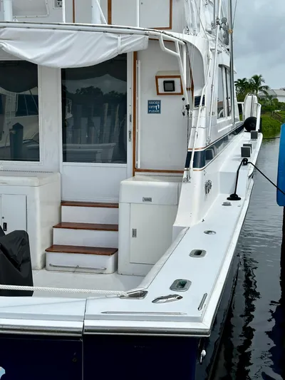 Farbrengen Yacht Photos Pics 1982 Bertram 54 Convertible yacht docked, featuring white exterior and wooden steps.