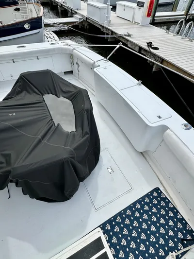 Farbrengen Yacht Photos Pics 1982 Bertram 54 Convertible boat deck with covered seating, docked at marina.