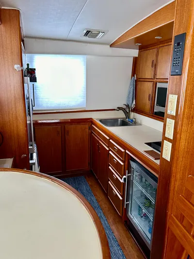 Farbrengen Yacht Photos Pics 1982 Bertram 54 Convertible yacht kitchen with wooden cabinetry and modern appliances.