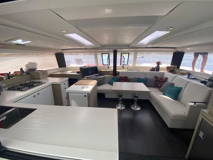 Enotan Yacht Photos Pics Luxurious interior of 2020 Fountaine Pajot Saona 47 catamaran with modern kitchen and seating area.