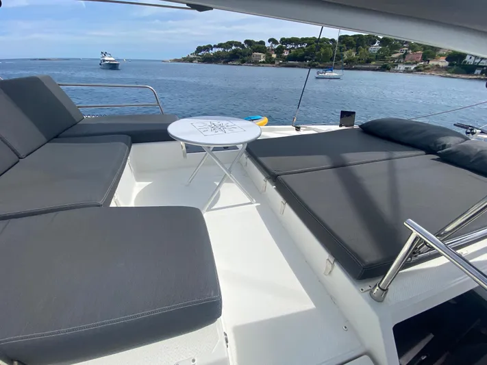 Enotan Yacht Photos Pics Luxurious 2020 Fountaine Pajot Saona 47 yacht deck with seating, table, and scenic ocean view.