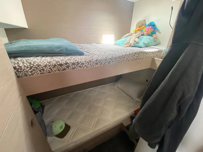 Enotan Yacht Photos Pics Bunk beds in 2020 Fountaine Pajot Saona 47 yacht cabin, featuring cozy bedding and plush toys.