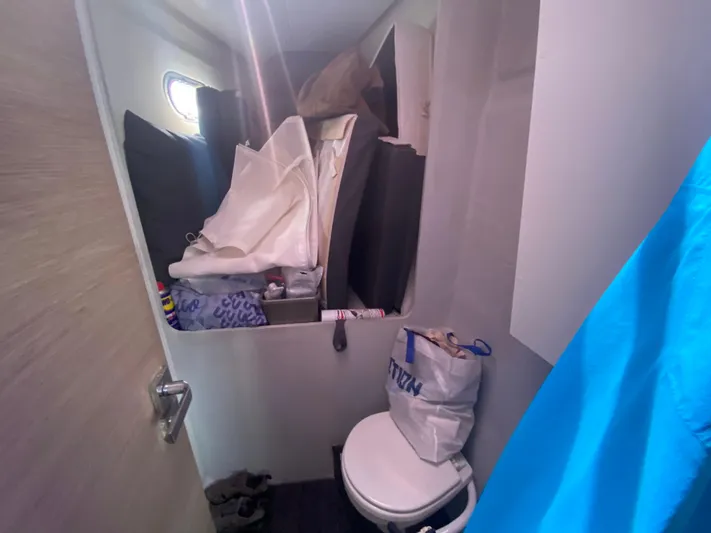 Enotan Yacht Photos Pics Small bathroom on 2020 Fountaine Pajot Saona 47, cluttered with bags and supplies.