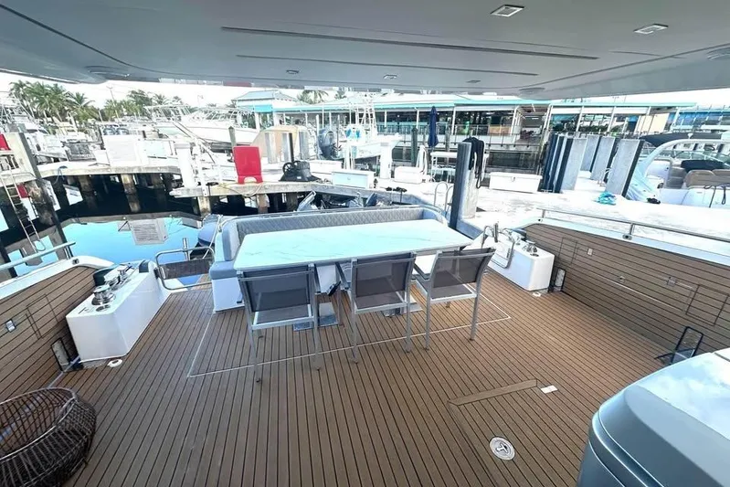 American Dream Yacht Photos Pics Luxurious 2023 Schaefer 660 yacht deck with dining area, docked at marina.
