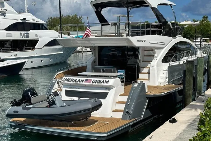American Dream Yacht Photos Pics Luxury Schaefer 660 yacht docked, featuring sleek design and American flag, 2023 model.