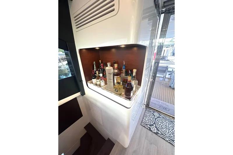 American Dream Yacht Photos Pics Luxurious bar area on Schaefer 660 yacht, featuring assorted liquor bottles, 2023 model.