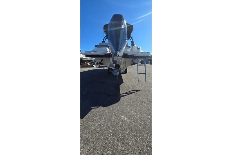  Yacht Photos Pics 2023 Sea Ray SDX 270 Outboard boat, rear view, parked on asphalt under clear blue sky.