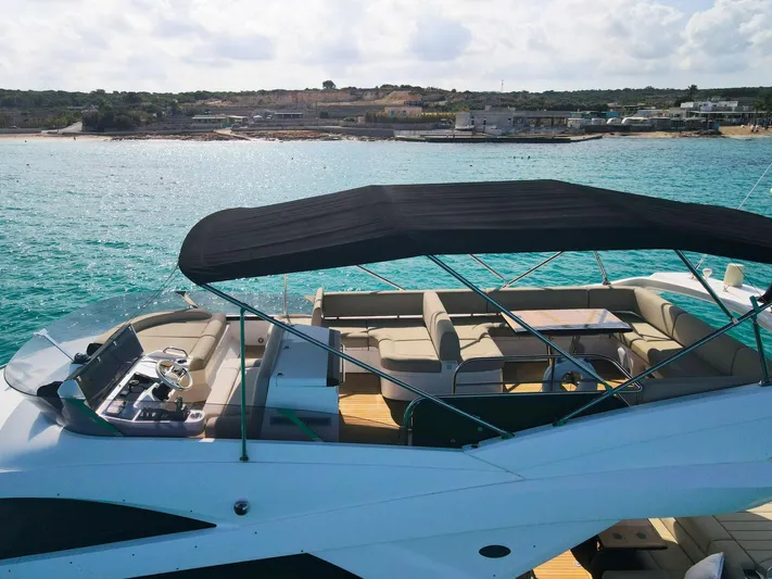 The Office Yacht Photos Pics Sunseeker Manhattan 55 yacht, 2015 model, with spacious deck and canopy on turquoise waters.