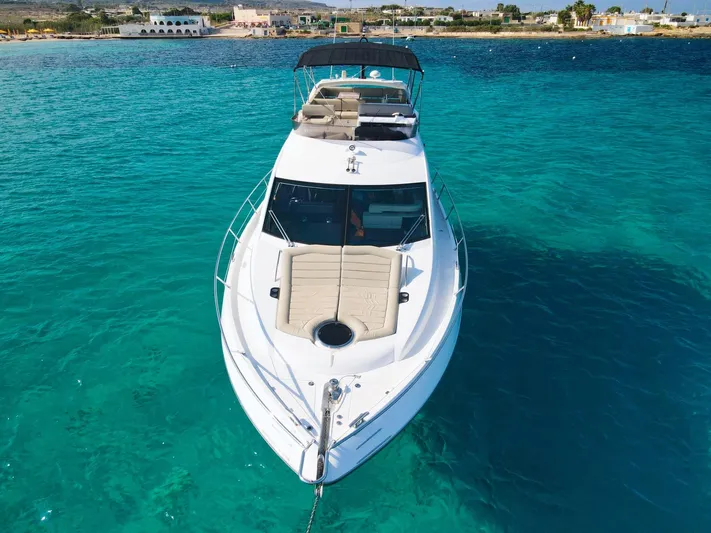 The Office Yacht Photos Pics Sunseeker Manhattan 55 yacht, 2015 model, anchored in clear turquoise waters.