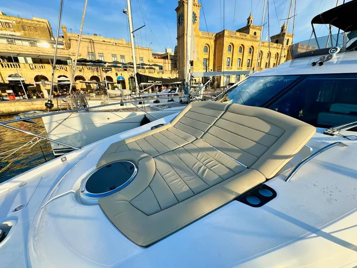 The Office Yacht Photos Pics Sunseeker Manhattan 55 yacht, 2015 model, docked with sunbed and historic buildings in background.
