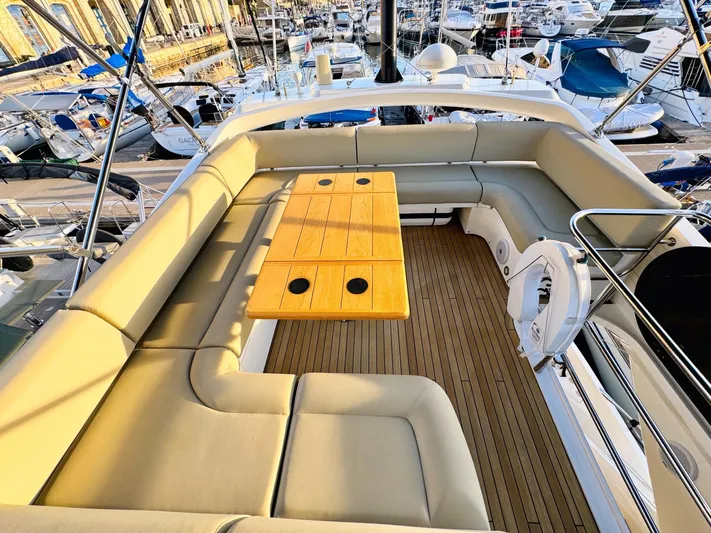 The Office Yacht Photos Pics Luxurious Sunseeker Manhattan 55 yacht deck with seating and table, docked at marina.