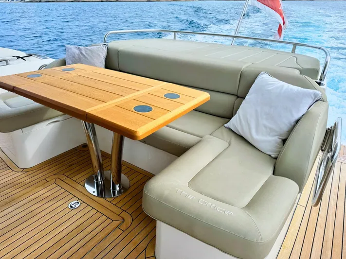 The Office Yacht Photos Pics Luxurious seating area on 2015 Sunseeker Manhattan 55 yacht with wooden table and cushions.
