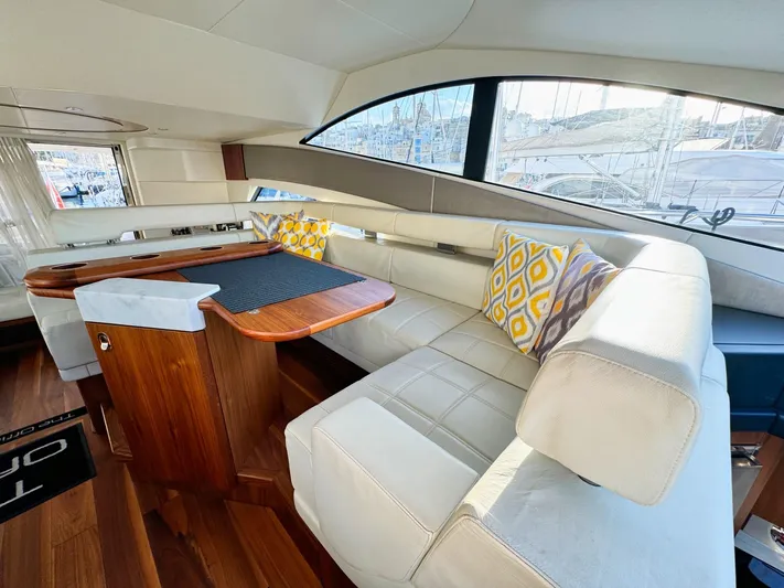 The Office Yacht Photos Pics Luxurious interior of 2015 Sunseeker Manhattan 55 yacht with elegant seating and wooden table.