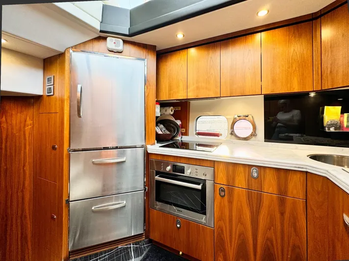 The Office Yacht Photos Pics Luxurious kitchen interior of 2015 Sunseeker Manhattan 55 yacht with wood cabinetry and stainless appliances.