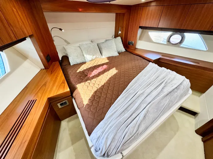 The Office Yacht Photos Pics Luxurious cabin interior of 2015 Sunseeker Manhattan 55 yacht with cozy bed and wooden accents.