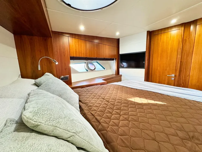 The Office Yacht Photos Pics Luxurious cabin interior of 2015 Sunseeker Manhattan 55 yacht with wood paneling and cozy bedding.