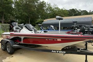2019 Nitro Z19 Pro boat on trailer, red and white, parked outdoors.