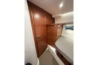 Interior of 2023 Nimbus 305 Coupe, featuring sleek wooden cabinetry and modern design.