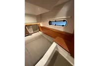 Interior cabin of 2023 Nimbus 305 Coupe with cozy bed and window view.