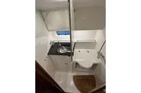 Compact bathroom in 2023 Nimbus 305 Coupe with sink, shower, and wooden floor mat.