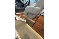 Interior of 2023 Nimbus 305 Coupe featuring helm seat and wooden cabinetry.