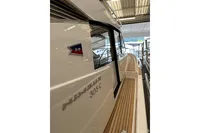 2023 Nimbus 305 Coupe boat with sleek design and wooden deck in showroom.